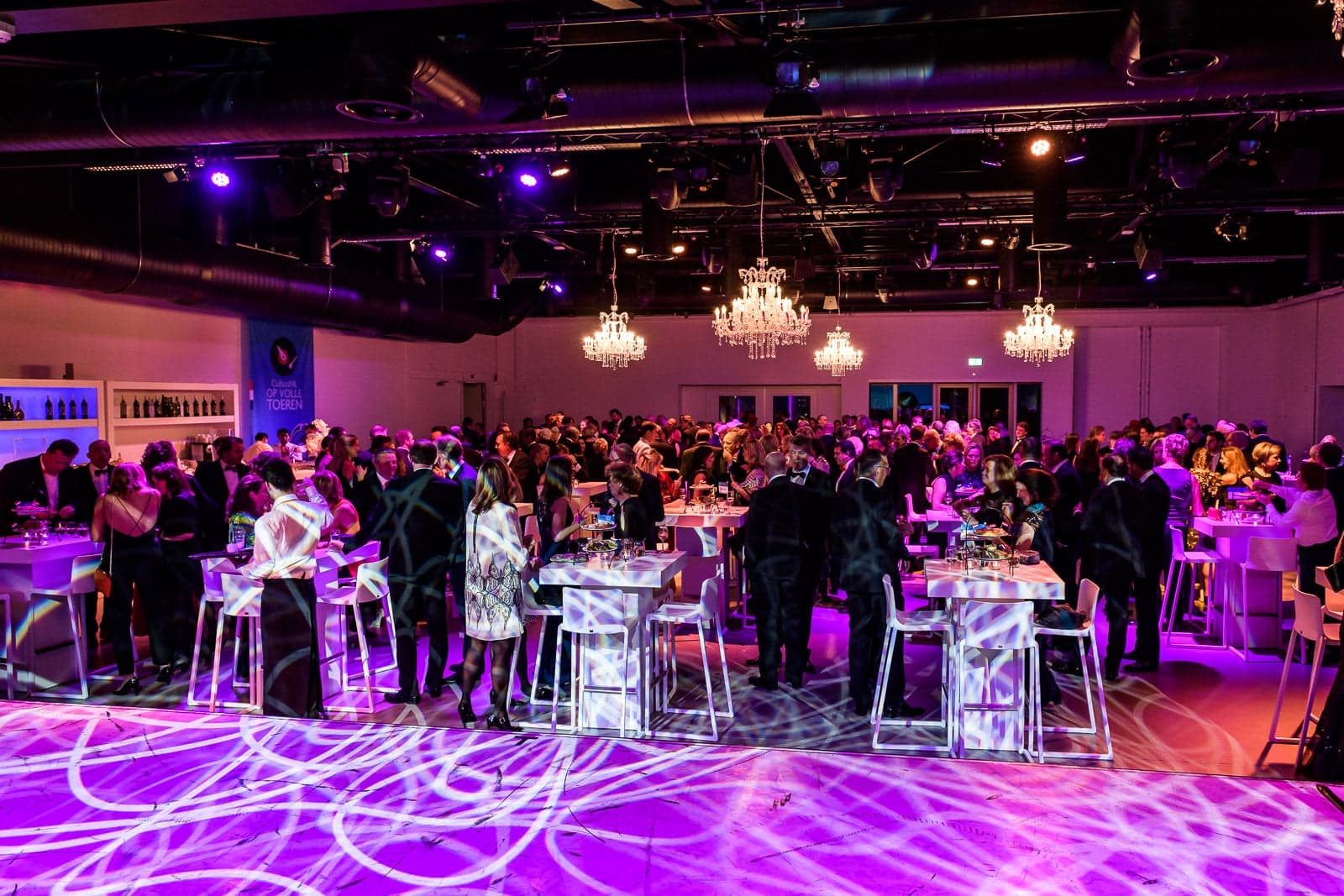 Bedrijfsborrel binnen met statafels en sfeerverlichting